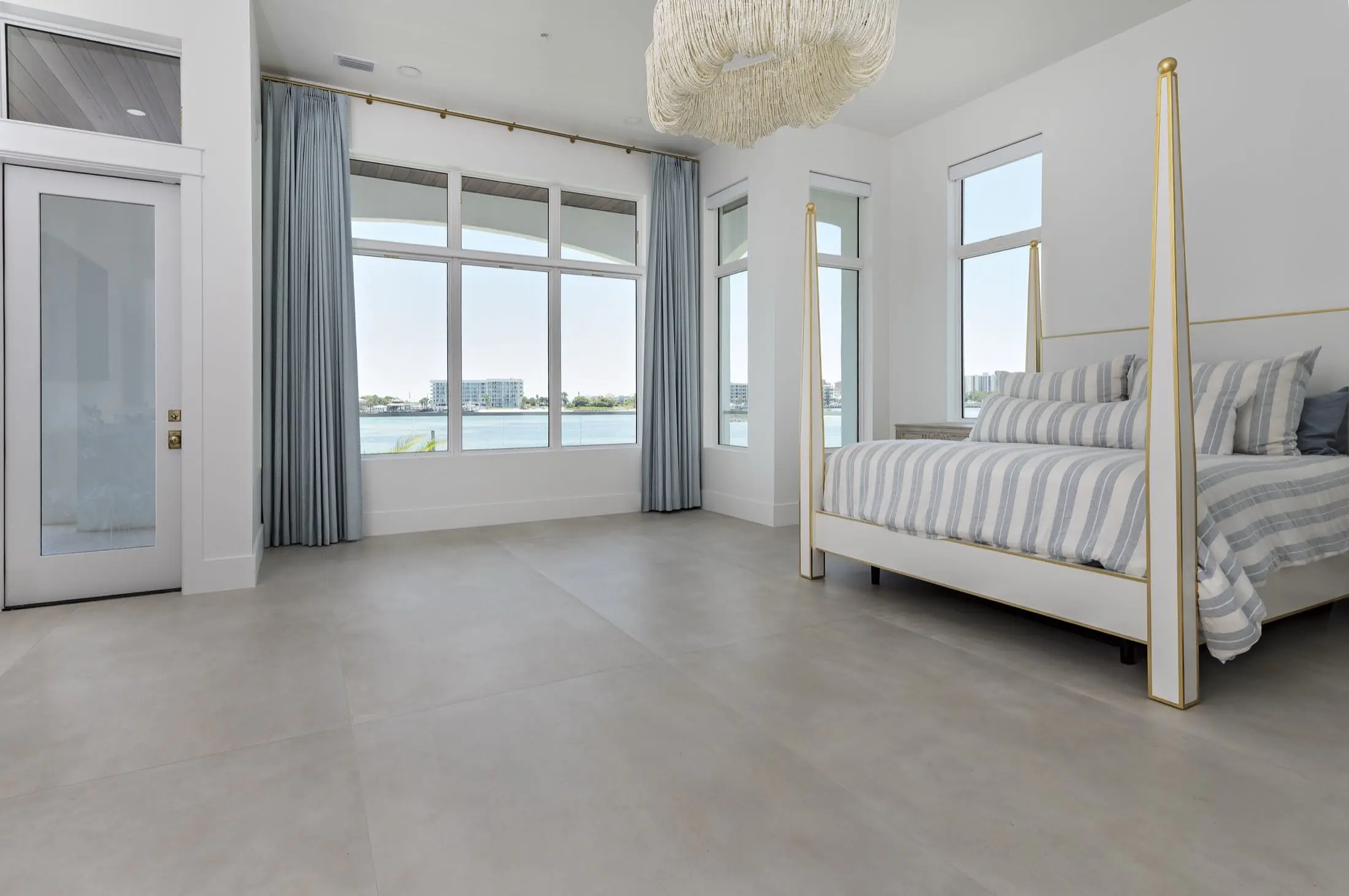 Waterfront primary bedroom with large-format tile flooring in an Orange Beach AL remodel