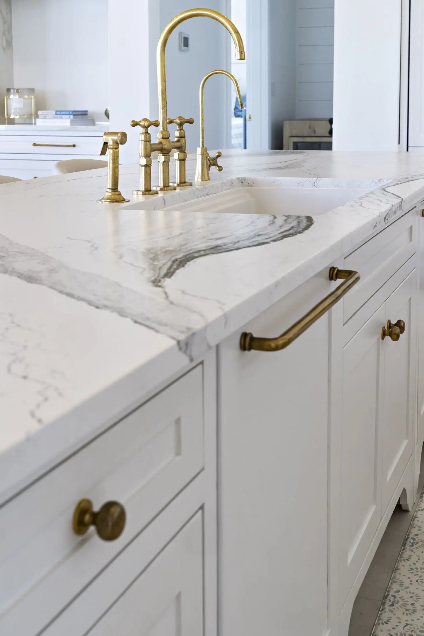 Kitchen island with stone countertop, integrated drainboard and brass bridge faucet