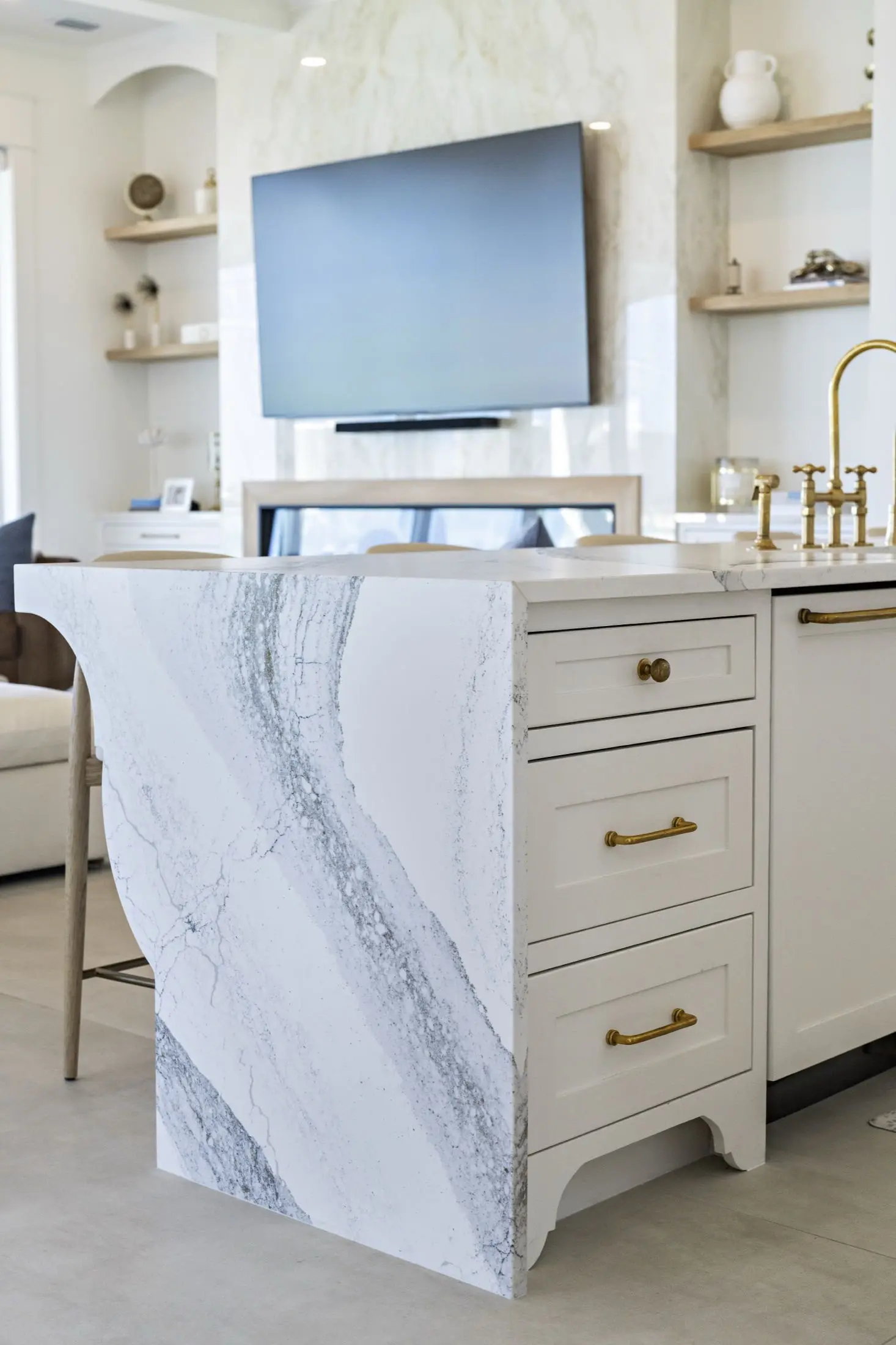 Kitchen island with a mitered waterfall edge in veined quartzite